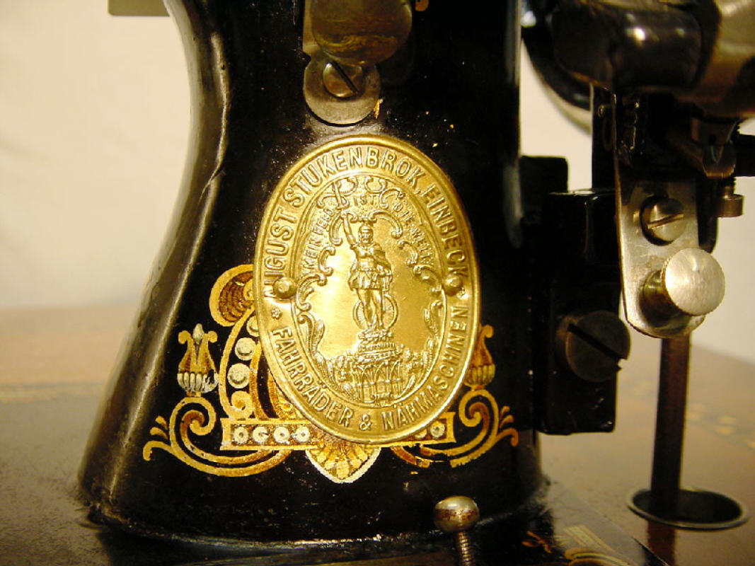 Das Messing Emblem von August Stukenbrok am Nähmaschinenkörper angebracht.