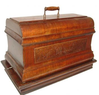 Handkurbel- Nähmaschine mit großer Holzhaube.